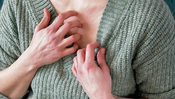 A woman scratching her chest A woman scratching her chest